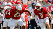 Sep 6, 2025; Raleigh, North Carolina, USA; North Carolina State Wolfpack offensive lineman Rico Jackson (64) celebrates a tackle against Virginia Cavaliers running back J'Mari Taylor (3) during the first half of the game at Carter-Finley Stadium. Mandatory Credit: Jaylynn Nash-Imagn Images