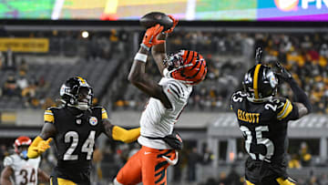 Jan 4, 2025; Pittsburgh, Pennsylvania, USA; Cincinnati Bengals wide receiver Tee Higgins (5) catches a pass in front of Pittsburgh Steelers cornerback Joey Porter Jr. (24) and safety DeShon Elliott (25) during the second quarter at Acrisure Stadium. Mandatory Credit: Barry Reeger-Imagn Images