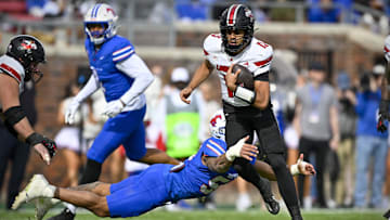 Nov 22, 2025; Dallas, Texas, USA; Louisville Cardinals quarterback Deuce Adams (13) is tackled by SMU Mustangs linebacker Alexander Kilgore (54) during the first half at Gerald J. Ford Stadium. Mandatory Credit: Jerome Miron-Imagn Images