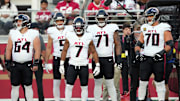 Atlanta Falcons running back Bijan Robinson stands alongside Ryan Neuzil and offensive tackles Elijah Wilkinson and Jake Matthews.
