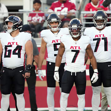 Atlanta Falcons running back Bijan Robinson stands alongside Ryan Neuzil and offensive tackles Elijah Wilkinson and Jake Matthews.
