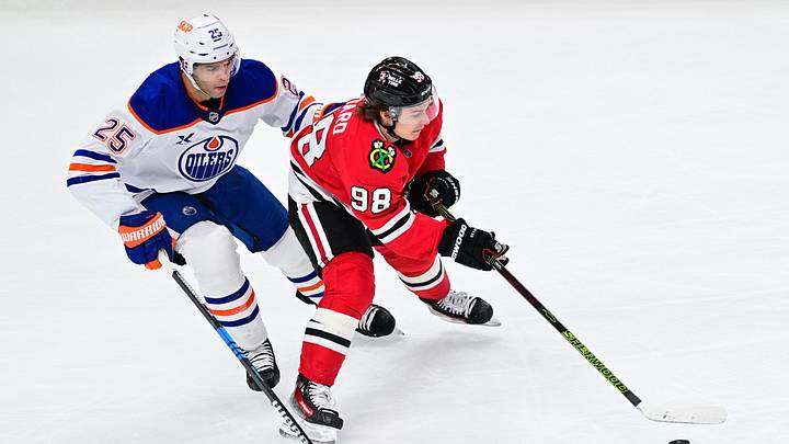 Feb 5, 2025; Chicago, Illinois, USA; Chicago Blackhawks center Connor Bedard (98) plays the puck as Edmonton Oilers defenseman Darnell Nurse (25) defends during the third period at the United Center. Mandatory Credit: Daniel Bartel-Imagn Images