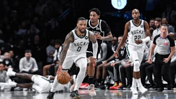 Milwaukee Bucks guard Damian Lillard brings the ball up court while being defended by Brooklyn Nets guard Keon Johnson during the second half at Barclays Center on Sunday.