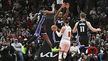 Jan 12, 2025; Chicago, Illinois, USA;  Sacramento Kings guard Malik Monk (0) and  forward DeMar DeRozan (10) block Chicago Bulls guard Zach LaVine (8) during the second half at United Center. Mandatory Credit: Matt Marton-Imagn Images