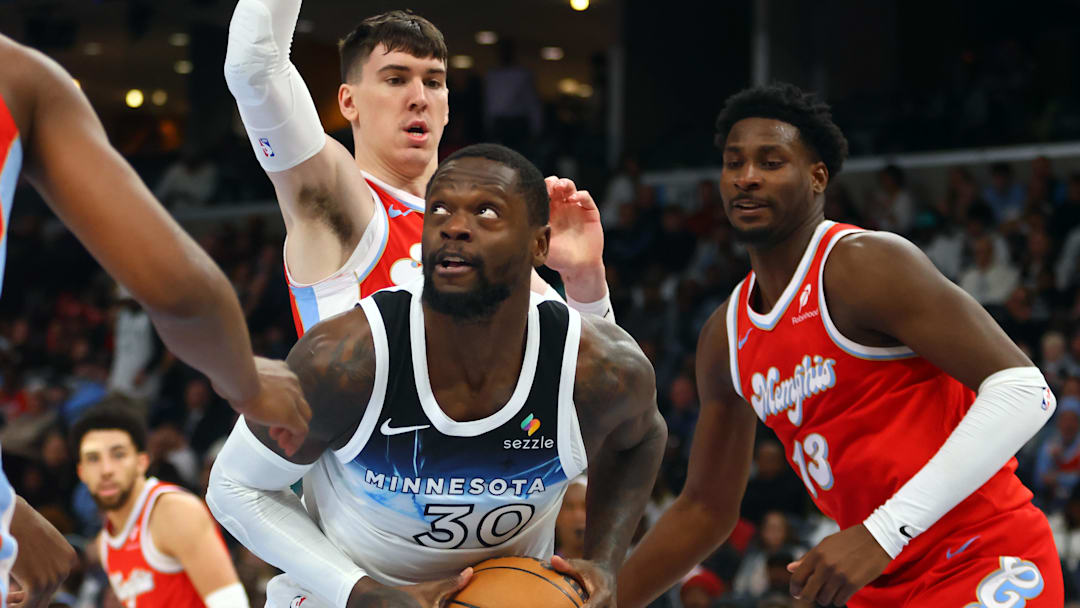 Jan 20, 2025; Memphis, Tennessee, USA; Minnesota Timberwolves forward Julius Randle (30) spins toward the basket as Memphis Grizzlies forward Jake LaRavia (3) and forward Jaren Jackson Jr. (13) defend during the fourth quarter at FedExForum. Mandatory Credit: Petre Thomas-Imagn Images