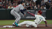 Apr 27, 2025; Phoenix, Arizona, USA; Arizona Diamondbacks outfielder Corbin Carroll (7) slides into thirdbase after hitting a triple in front of Atlanta Braves third base Austin Riley (27) in the first inning at Chase Field. Mandatory Credit: Rick Scuteri-Imagn Images