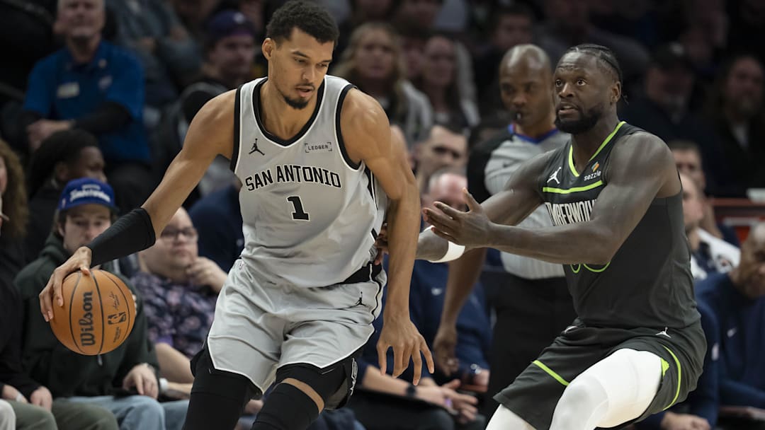 Jan 11, 2026; Minneapolis, Minnesota, USA; San Antonio Spurs forward Victor Wembanyama (1) dribbles the ball as Minnesota Timberwolves forward Julius Randle (30) plays defense in the second half at Target Center.