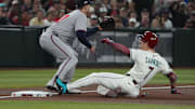 Corbin Carroll slides safely into third base for one of his two triples against the Braves on Sunday.