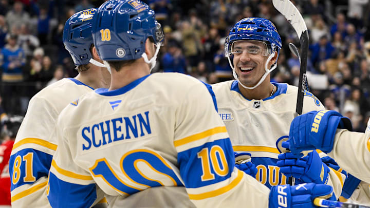 Feb 8, 2025; St. Louis, Missouri, USA;  St. Louis Blues right wing Mathieu Joseph (71) celebrates with center Dylan Holloway (81) and center Brayden Schenn (10) after scoring against the Chicago Blackhawks during the second period at Enterprise Center. Mandatory Credit: Jeff Curry-Imagn Images