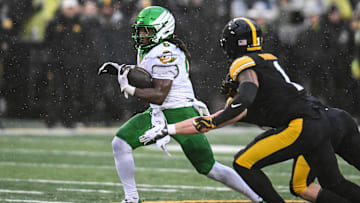 Nov 8, 2025; Iowa City, Iowa, USA; Oregon Ducks running back Noah Whittington (6) runs the ball as Iowa Hawkeyes linebacker Karson Sharar (obscured) and defensive back Xavier Nwankpa (1) attempt to make the tackle during the first quarter at Kinnick Stadium. Mandatory Credit: Jeffrey Becker-Imagn Images