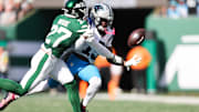 Oct 19, 2025; East Rutherford, New Jersey, USA; New York Jets defensive back Malachi Moore (27) punches the ball away from Carolina Panthers wide receiver Jimmy Horn Jr. (15) in the second quarter at MetLife Stadium. Mandatory Credit: Vincent Carchietta-Imagn Images