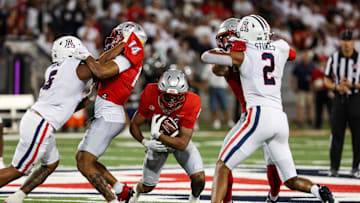 Aug 31, 2024; Tucson, Arizona, USA; New Mexico player runs through Arizona Wildcats linebacker Jacob Manu and Arizona Wildcats defensive back Treydan Stokes (2) during third quarter at Arizona Stadium. Mandatory Credit: Aryanna Frank-Imagn Images