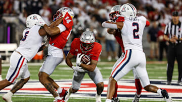 Aug 31, 2024; Tucson, Arizona, USA; New Mexico player runs through Arizona Wildcats linebacker Jacob Manu and Arizona Wildcats defensive back Treydan Stokes (2) during third quarter at Arizona Stadium.