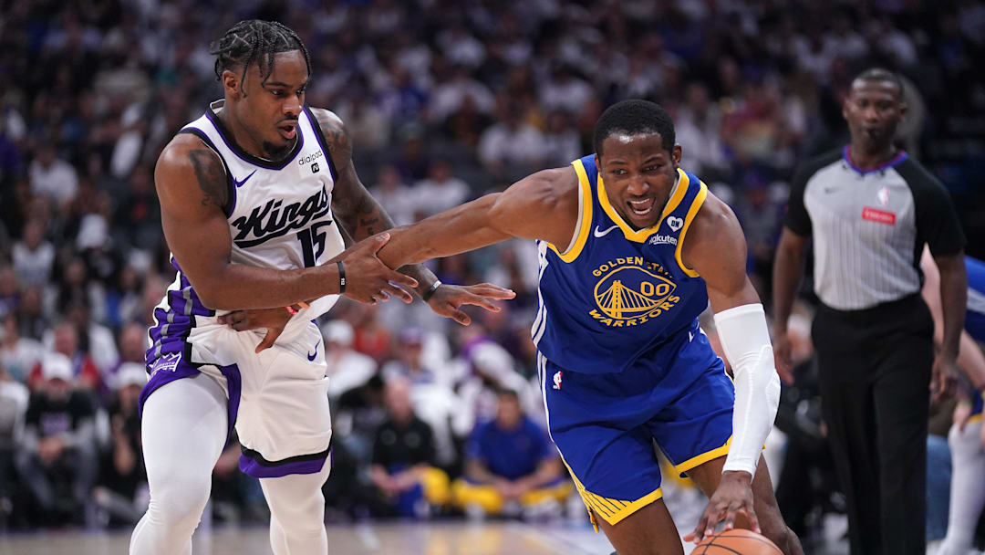Apr 16, 2024; Sacramento, California, USA; Golden State Warriors forward Jonathan Kuminga (00) dribbles past Sacramento Kings guard Davion Mitchell (15) in the second quarter during a play-in game of the 2024 NBA playoffs at the Golden 1 Center. Mandatory Credit: Cary Edmondson-Imagn Images