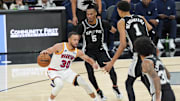 Nov 23, 2024; San Antonio, Texas, USA;  Golden State Warriors guard Stephen Curry (30) dribbles in front of San Antonio Spurs guard Stephon Castle (5) and center Victor Wembanyama (1) in the second half at Frost Bank Center. Mandatory Credit: Daniel Dunn-Imagn Images
