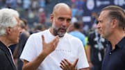 Jul 27, 2024; New York, NY, USA; Manchester City head coach Pep Guardiola speaks with Marty Edelman, left, and AC Milan owner Gerry Cardinale before the match between AC Milan and Manchester City at Yankee Stadium. Mandatory Credit: Lucas Boland-Imagn Images