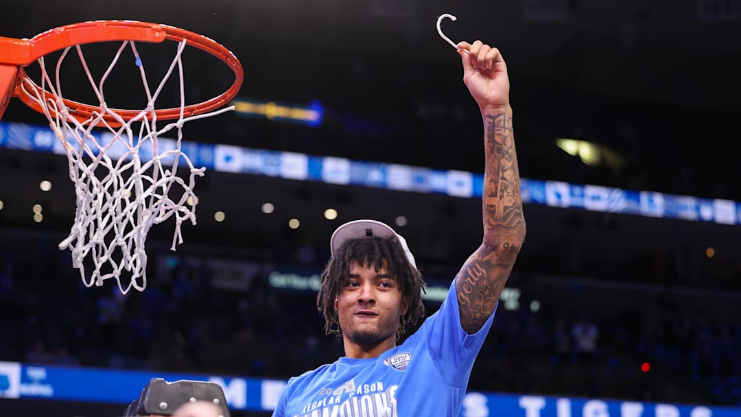 Mar 7, 2025; Memphis, Tennessee, USA; Memphis Tigers guard PJ Haggerty (4) cuts the net after winning the game against the South Florida Bulls at FedExForum. Mandatory Credit: Wesley Hale-Imagn Images