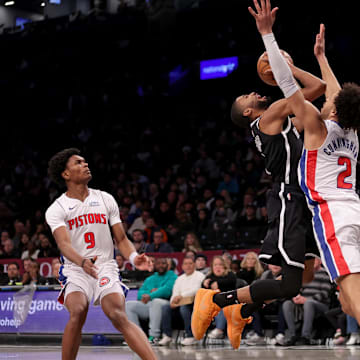 Dec 23, 2023; Brooklyn, New York, USA; Brooklyn Nets forward Mikal Bridges (1) is fouled as he drives to the basket by Detroit Pistons guard Cade Cunningham (2) in front of Pistons forward Ausar Thompson (9) during the first quarter at Barclays Center. Mandatory Credit: Brad Penner-Imagn Images