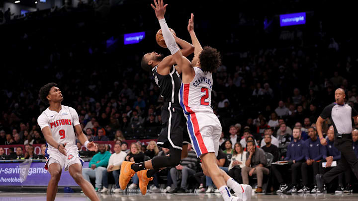 Dec 23, 2023; Brooklyn, New York, USA; Brooklyn Nets forward Mikal Bridges (1) is fouled as he drives to the basket by Detroit Pistons guard Cade Cunningham (2) in front of Pistons forward Ausar Thompson (9) during the first quarter at Barclays Center. Mandatory Credit: Brad Penner-Imagn Images