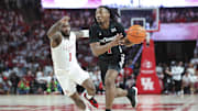 Feb 27, 2024; Houston, Texas, USA; Cincinnati Bearcats guard Day Day Thomas (1) drives with the ball as Houston Cougars guard Jamal Shead (1) defends during the first half at Fertitta Center. Mandatory Credit: Troy Taormina-Imagn Images