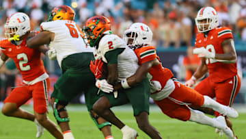 Sep 7, 2024; Miami Gardens, Florida, USA; Florida A&M Rattlers wide receiver Jamari Gassett (2) runs with the football against Miami Hurricanes defensive back Zaquan Patterson (20) during the second quarter at Hard Rock Stadium. Mandatory Credit: Sam Navarro-Imagn Images