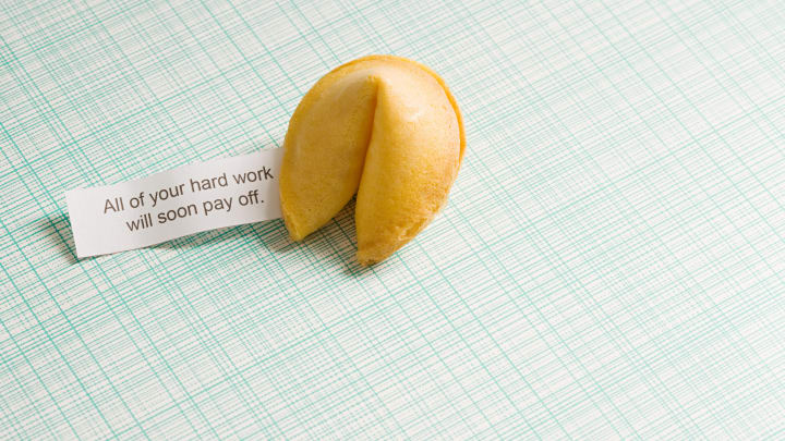 fortune cookie and fortune on a green striped background