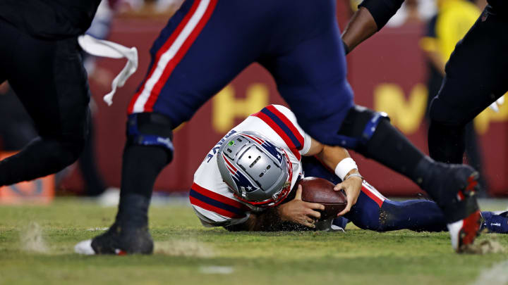 Aug 25, 2024; Landover, Maryland, USA; New England Patriots quarterback Drake Maye (10) recovers a fumble snap during the first quarter against the Washington Commanders during a preseason game at Commanders Field. Mandatory Credit: Peter Casey-USA TODAY Sports