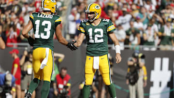 Sep 25, 2022; Tampa, Florida, USA; Green Bay Packers quarterback Aaron Rodgers (12)  and wide receiver Allen Lazard (13) congratulate each other after they scored a touchdown against the Tampa Bay Buccaneers during the first quarter at Raymond James Stadium.
