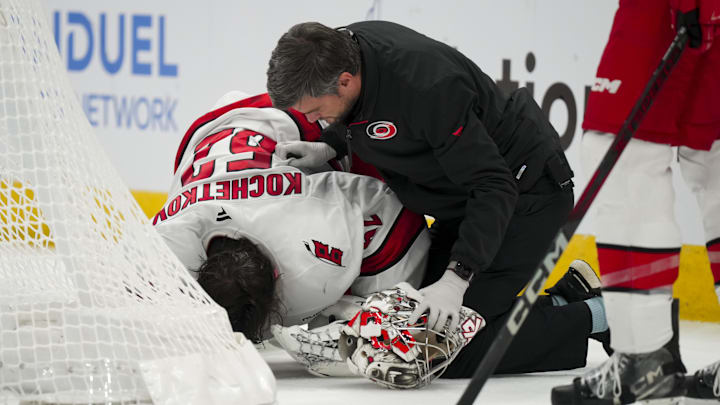 Nov 23, 2024; Columbus, Ohio, USA;  Carolina Hurricanes goaltender Pyotr Kochetkov (52) is tended to by the Hurricanes’ head athletic trainer Doug Bennett during a stop in play in the game against the Columbus Blue Jackets in the overtime period at Nationwide Arena. Mandatory Credit: Aaron Doster-Imagn Images