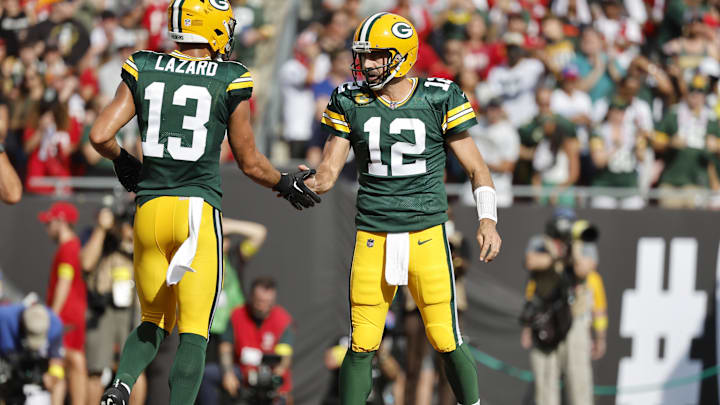 Sep 25, 2022; Tampa, Florida, USA; Green Bay Packers quarterback Aaron Rodgers (12)  and wide receiver Allen Lazard (13) congratulate each other after they scored a touchdown against the Tampa Bay Buccaneers during the first quarter at Raymond James Stadium.