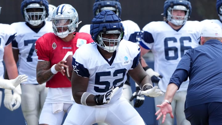 Dallas Cowboys quarterback Dak Prescott prepares to take the snap as guard Tyler Booker blocks at training camp Dallas Cowboys quarterback Dak Prescott prepares to take the snap as guard Tyler Booker blocks at training camp