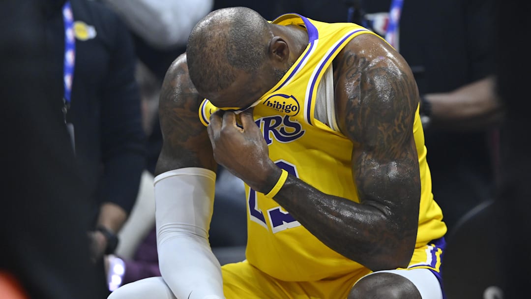 Jan 28, 2026; Cleveland, Ohio, USA; Los Angeles Lakers forward LeBron James (23) reacts on the bench during a video tribute shown on the scoreboard during a timeout in the first quarter against the Cleveland Cavaliers at Rocket Arena. Mandatory Credit: David Richard-Imagn Images