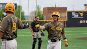 West Virginia utility infielder Sam White (11) is greeted by first baseman Grant Hussey (9) at the plate in the fourth inning against Texas Tech