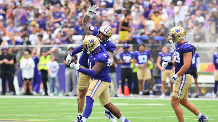 Sep 7, 2024; Seattle, Washington, USA; Washington Huskies defensive lineman Jacob Bandes (55) celebrates with defensive lineman Deshawn Lynch (41) after a defensive stop against the Eastern Michigan Eagles during the second half at Alaska Airlines Field at Husky Stadium. Mandatory Credit: Steven Bisig-Imagn Images
