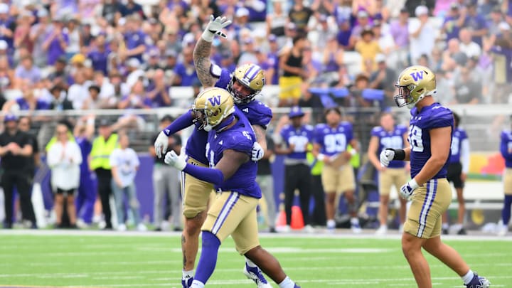 Sep 7, 2024; Seattle, Washington, USA; Washington Huskies defensive lineman Jacob Bandes (55) celebrates with defensive lineman Deshawn Lynch (41) after a defensive stop against the Eastern Michigan Eagles during the second half at Alaska Airlines Field at Husky Stadium. Mandatory Credit: Steven Bisig-Imagn Images