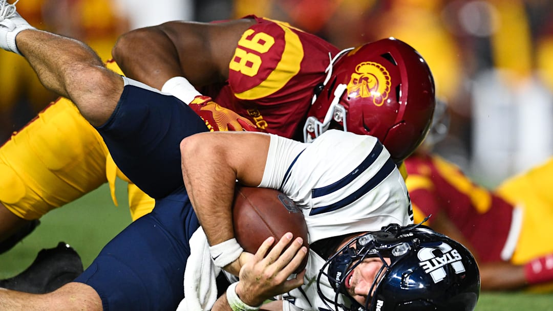 Sep 7, 2024; Los Angeles, California, USA; USC Trojans defensive end Devan Thompkins (98) sacks Utah State Aggies quarterback Bryson Barnes (16) during the third quarter at United Airlines Field at Los Angeles Memorial Coliseum. Mandatory Credit: Jonathan Hui-Imagn Images