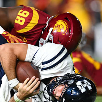 Sep 7, 2024; Los Angeles, California, USA; USC Trojans defensive end Devan Thompkins (98) sacks Utah State Aggies quarterback Bryson Barnes (16) during the third quarter at United Airlines Field at Los Angeles Memorial Coliseum. Mandatory Credit: Jonathan Hui-Imagn Images