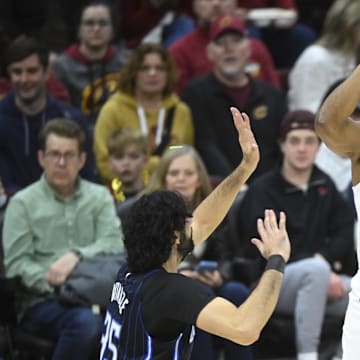 Mar 16, 2025; Cleveland, Ohio, USA; Cleveland Cavaliers guard Donovan Mitchell (45) shoots beside Orlando Magic center Goga Bitadze (35) in the fourth quarter at Rocket Arena. Mandatory Credit: David Richard-Imagn Images
