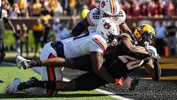 Oct 19, 2024; Columbia, Missouri, USA; Missouri Tigers running back Jamal Roberts (20) scores a touchdown against Auburn Tigers cornerback Mac McClinton (27) and safety Kaleb Harris (18) during the second half at Faurot Field at Memorial Stadium. Mandatory Credit: Jay Biggerstaff-Imagn Images