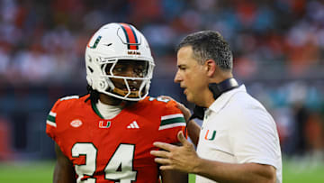 Sep 7, 2024; Miami Gardens, Florida, USA; Miami Hurricanes head coach Mario Cristobal talks to Miami Hurricanes linebacker Malik Bryant (24) during the second quarter at Hard Rock Stadium. Mandatory Credit: Sam Navarro-Imagn Images