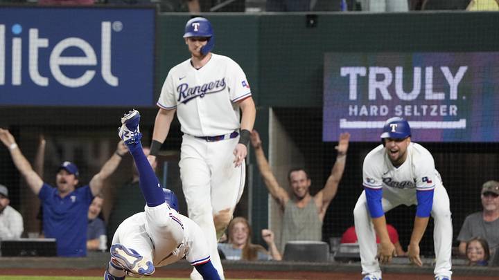 May 17, 2022; Arlington, Texas, USA; Texas Rangers left fielder Eli White (41) dives to score on a fielding error by Los Angeles Angels left fielder Brandon Marsh (not shown) during the eighth inning of a baseball game at Globe Life Field. The Rangers won 10-5. Mandatory Credit: Jim Cowsert-Imagn Images