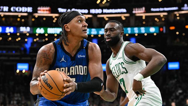 Jan 17, 2025; Boston, Massachusetts, USA; Orlando Magic forward Paolo Banchero (5) looks to shoot through the defense of Boston Celtics guard Jaylen Brown (7) during the first half at TD Garden. Mandatory Credit: Eric Canha-Imagn Images