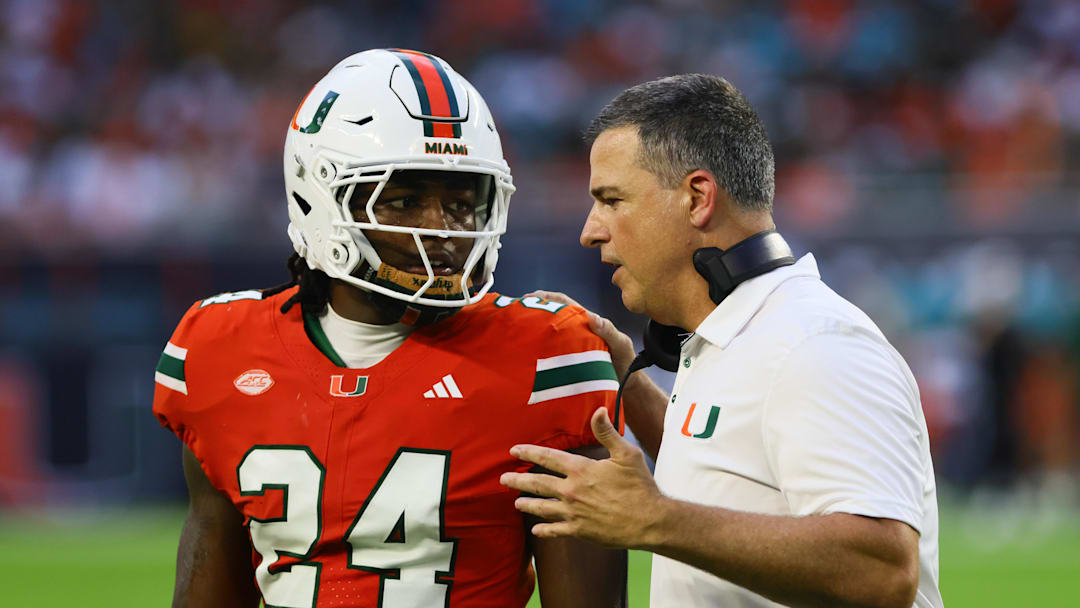 Sep 7, 2024; Miami Gardens, Florida, USA; Miami Hurricanes head coach Mario Cristobal talks to Miami Hurricanes linebacker Malik Bryant (24) during the second quarter at Hard Rock Stadium. Mandatory Credit: Sam Navarro-Imagn Images