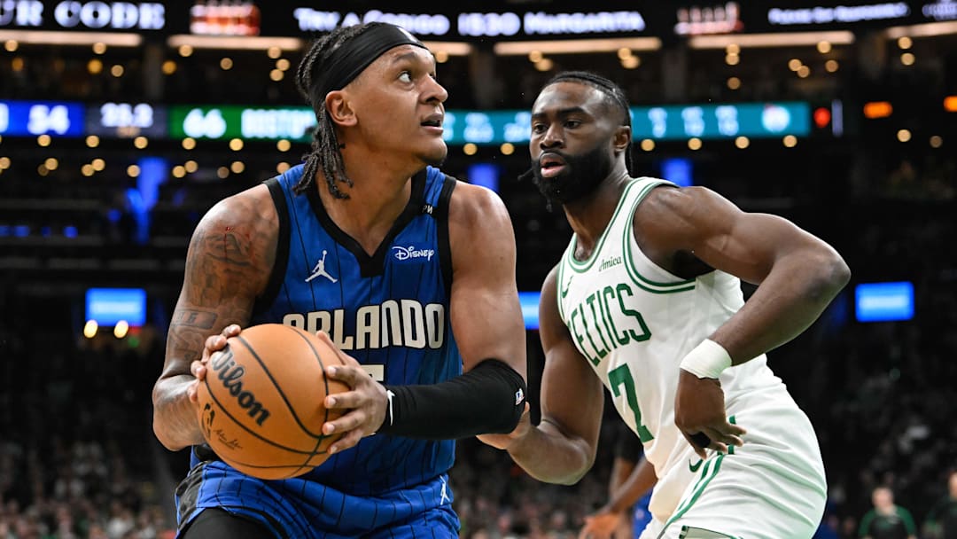 Jan 17, 2025; Boston, Massachusetts, USA; Orlando Magic forward Paolo Banchero (5) looks to shoot through the defense of Boston Celtics guard Jaylen Brown (7) during the first half at TD Garden. Mandatory Credit: Eric Canha-Imagn Images