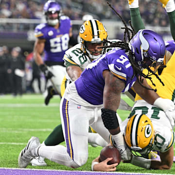 Green Bay Packers quarterback Jordan Love scores on a touchdown run as Minnesota Vikings linebacker Pat Jones II (91) and safety Camryn Bynum defend during the second quarter at U.S. Bank Stadium in Minneapolis on Dec. 31, 2023.