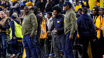Injured Michigan running back Justice Haynes, center, talks to running backs coach Tony Alford, left, and Fred Jackson, senior offensive analyst/running backs, during warmups ahead of the Purdue game at Michigan Stadium in Ann Arbor on Saturday, November 1, 2025.