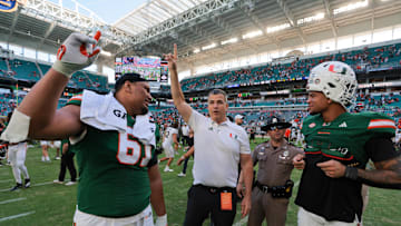 Nov 23, 2024; Miami Gardens, Florida, USA; Miami Hurricanes head coach Mario Cristobal celebrates with Miami Hurricanes offensive lineman Francis Mauigoa (61) and tight end Elijah Arroyo (8) after the game against the Wake Forest Demon Deacons at Hard Rock Stadium. Mandatory Credit: Sam Navarro-Imagn Images