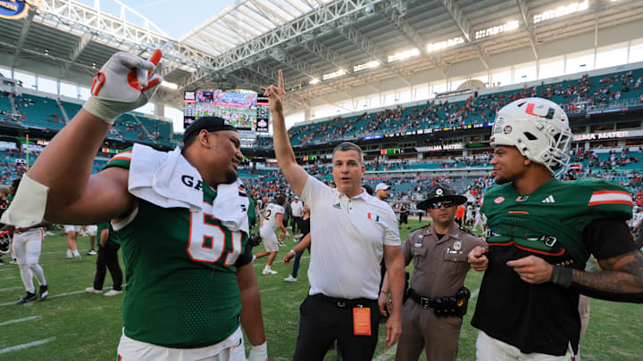 Nov 23, 2024; Miami Gardens, Florida, USA; Miami Hurricanes head coach Mario Cristobal celebrates with Miami Hurricanes offensive lineman Francis Mauigoa (61) and tight end Elijah Arroyo (8) after the game against the Wake Forest Demon Deacons at Hard Rock Stadium. Mandatory Credit: Sam Navarro-Imagn Images