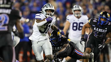 Nov 18, 2023; Lawrence, Kansas, USA; Kansas State Wildcats running back DJ Giddens (31) runs the ball against Kansas Jayhawks defensive lineman D.J. Withers (52) during the second half at David Booth Kansas Memorial Stadium. Mandatory Credit: Jay Biggerstaff-Imagn Images
