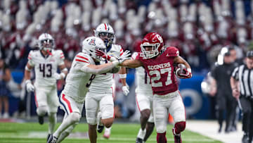 Dec 28, 2023; San Antonio, TX, USA;  Oklahoma Sooners running back Gavin Sawchuk (27) fends off Arizona Wildcats safety Gunner Maldonado (9) in the first half at Alamodome. Mandatory Credit: Daniel Dunn-Imagn Images